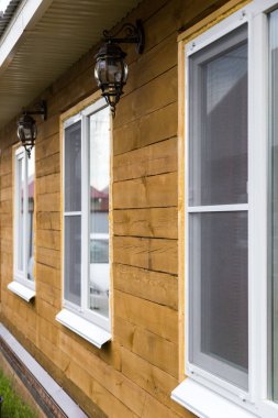 Tahtadan yapılmış bir ev cephesinde Plastik pencere