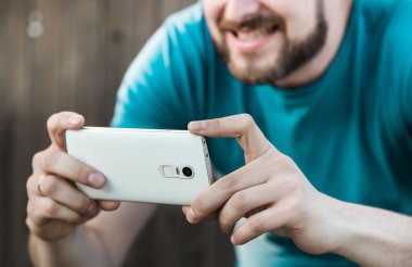 Bir sakallı bir adam fotoğraf Smartphone'da çeker.