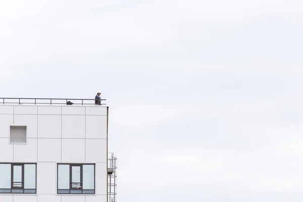Ufa, Rusya - 21 Mayıs 2016: İdil kulesi. Mühendis bir kask içinde modern bir binanın çatı üzerinde sırtında — Stok fotoğraf