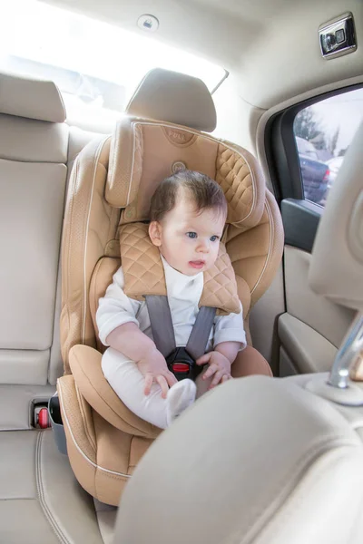 child in a baby car seat. Isofix clamping. beige car seat in a bright salon