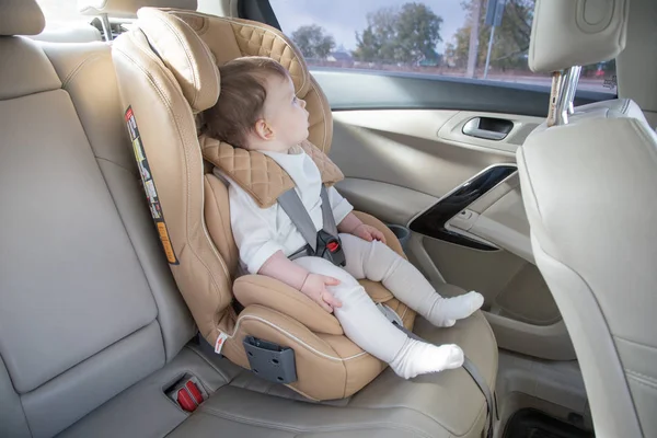 child in a baby car seat. Isofix clamping. beige car seat in a bright salon