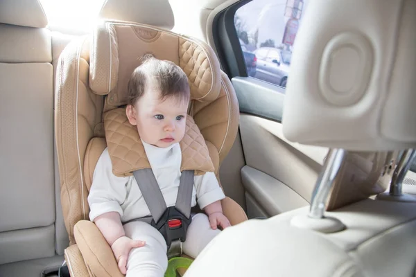 孩子坐在婴儿车座上。Isofix 夹紧。米色汽车座椅在明亮的沙龙 — 图库照片