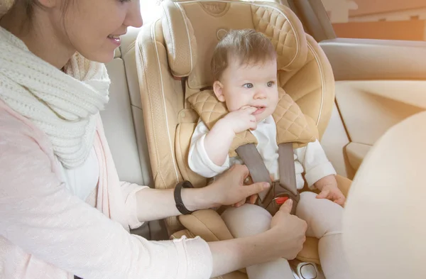 Mom fastens the child in the child seat — Stock Photo, Image