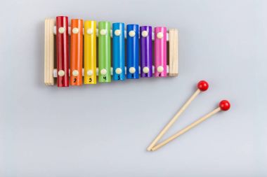 Renkli ksilofon ve beyaz arka planda sopa. Yukarıdan görünüm
