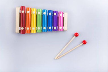 Renkli ksilofon ve beyaz arka planda sopa. Yukarıdan görünüm