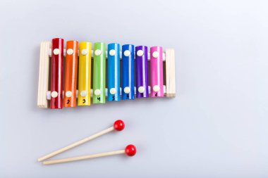 Renkli ksilofon ve beyaz arka planda sopa. Yukarıdan görünüm