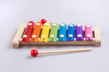 Renkli ksilofon ve beyaz arka planda sopa. Yukarıdan görünüm