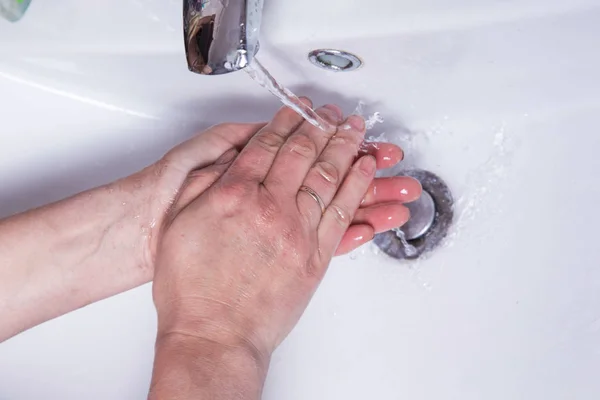 Lavare le mani delle donne sporche sotto l'acqua corrente in un primo piano lavabo — Foto Stock