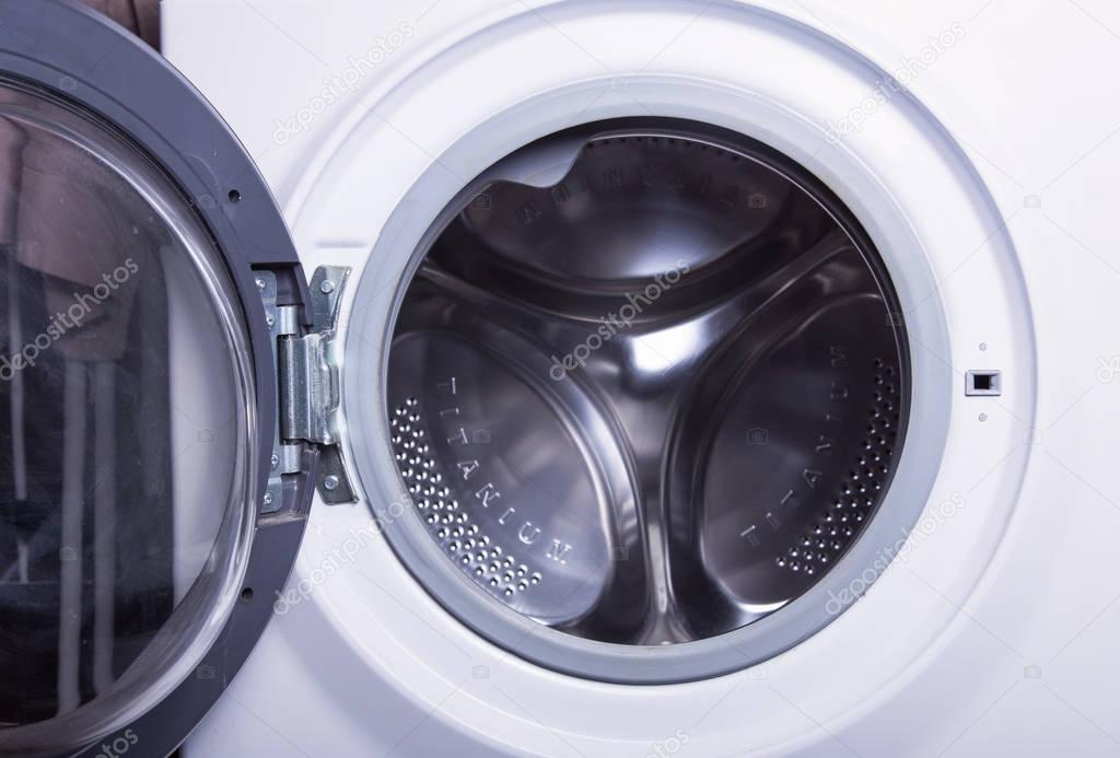 white washing machine with an open door. interior details