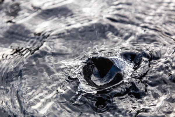 Vallende druppels op het wateroppervlak. textuur van het wateroppervlak — Stockfoto