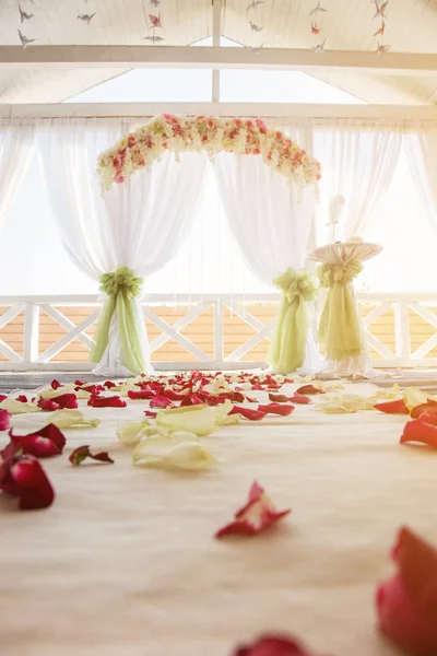 Rosenblad på golvet mot bröllopet bågen. — Stockfoto
