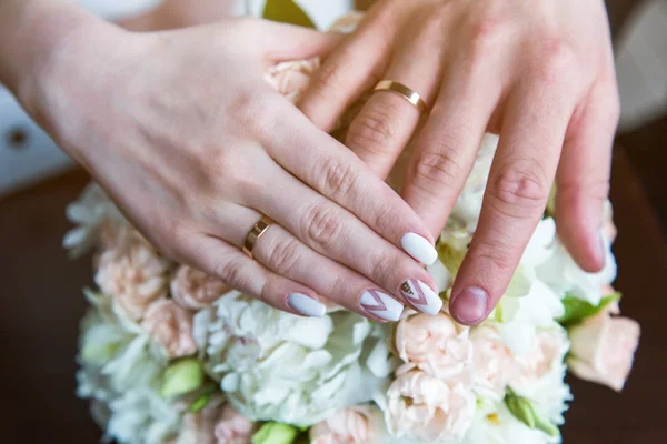 Les mains des mariés avec un anneau dans les bras — Photo