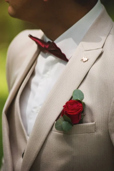 Boutonniere-a egy vörös rózsa a fehér kabát a vőlegény — Stock Fotó