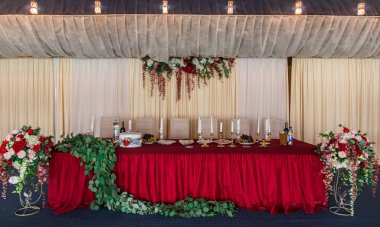 Yeni evliler için düğün tablo. taze çiçekler ve kırmızı bir masa örtüsü ile dekore edilmiş