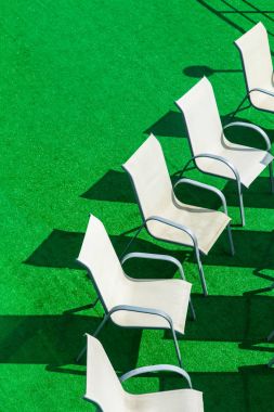 Beyaz sandalye weddibg töreni için yapay bir yeşil yüzeyinde gölge. Manzaralı abowe üzerinden