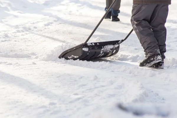 Man met schop reinigt de sneeuw — Stockfoto