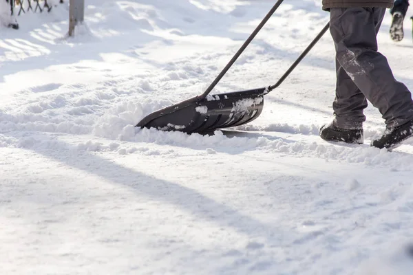 Людина з лопатою очищає сніг — стокове фото
