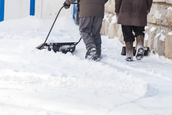 Man met schop reinigt de sneeuw — Stockfoto