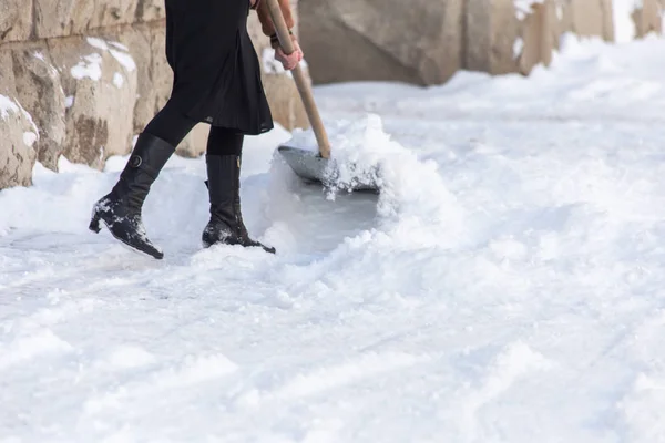 Vrouw met schop reinigt de sneeuw — Stockfoto