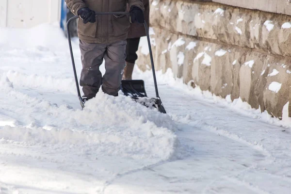 Hombre con pala limpia la nieve — Foto de Stock