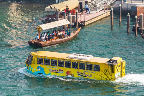 Dubai, Birleşik Arap Emirlikleri 14 Şubat 2018: Su turist ulaşım. su turist ulaşım: zümrüt su arka plan üzerinde turist nehir sarı otobüs