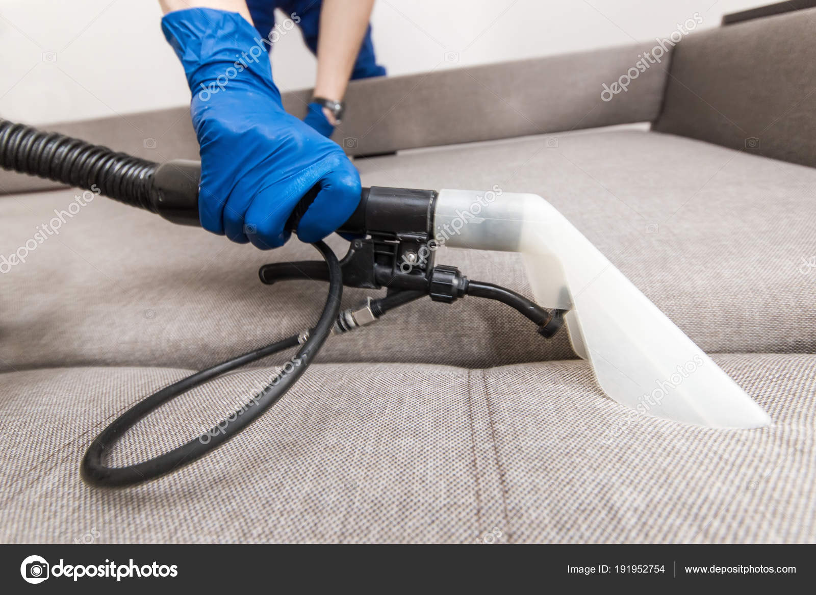 Cleaning Service Man Janitor In Gloves And Uniform Vacuum Clean Sofa