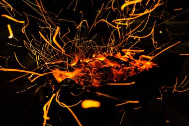 parlak turuncu bir kamp ateşi uzun pozlama ve için için yanan kömürlerin üzerinde gelen kıvılcım. Dynamics satırları izlemeler.