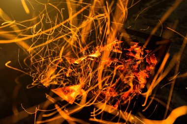 parlak turuncu bir kamp ateşi uzun pozlama ve için için yanan kömürlerin üzerinde gelen kıvılcım. Dynamics satırları izlemeler.