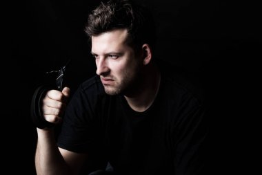 Bir kemer bir siyah arka plan üzerinde tutarak kızgın bir adam portresi. Aile çatışmalar ve şiddet. Saldırganlık kavramı