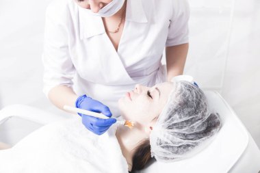 Bir kadın makyajcısı Doktor Genç bir kızın hasta ile çalışır ve bir krem yüzünde uygular. Güzellik ve Cilt Bakımı.