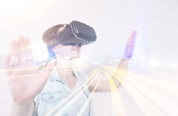 Hermosa mujer jugando juego en gafas de realidad virtual. realidad complementada en una doble exposición — Foto de Stock