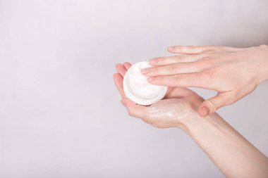 Beyaz bir backgro üzerinde kozmetik bir kavanoz ile eller yakın çekim