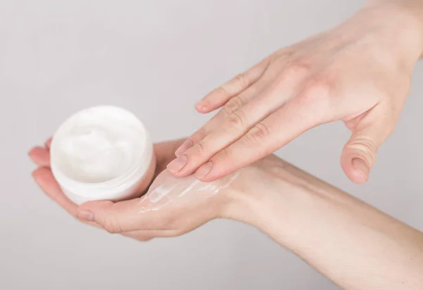 Female hands close-up with a jar of cosmetics on a white backgro — Stock Photo, Image