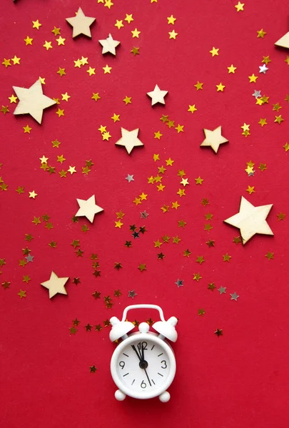 Flat lay composition. Alarm clock and Christmas decorations on red background. top view, copy space — Stock Photo, Image