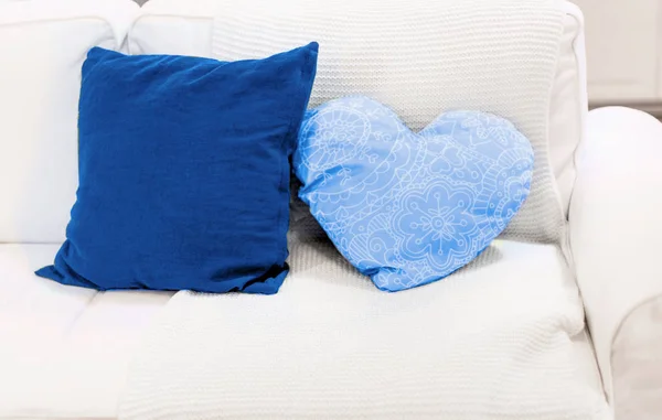 Затишний білий диван і яскраво-блакитні подушки. білий і мінімалістичний дизайн інтер'єру. люди і гармонія в сім'ї і вдома — стокове фото