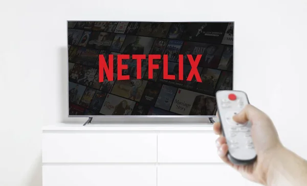 Уфи, Росія-Jule 7, 2019: стіл з попкорн пляшку і Netflix логотип на смартфоні. Netflix є світовим постачальником потокового фільми і серіали — стокове фото