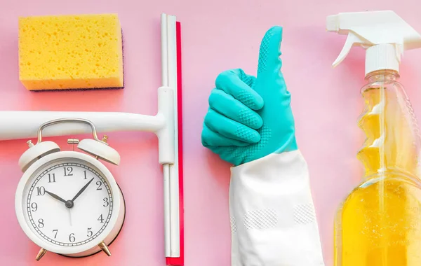 Tiempo de limpieza. Productos de limpieza de color de la casa en mesa rosa —  Fotos de Stock
