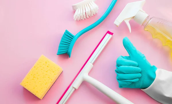 Casa produtos de limpeza coloridos na mesa rosa — Fotografia de Stock