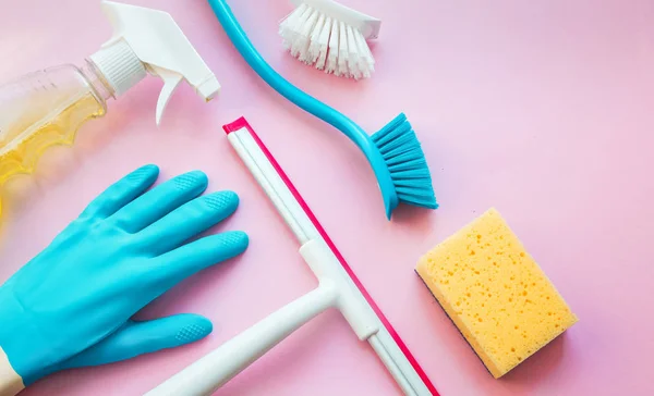 Casa produtos de limpeza coloridos na mesa rosa — Fotografia de Stock