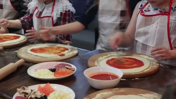 Los niños cocinan pizza. Clase magistral del chef en un restaurante, Primer plano de los niños manos desplegar la masa — Vídeos de Stock