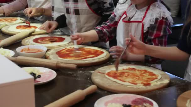 Los niños cocinan pizza. Clase magistral del chef en un restaurante, Primer plano de los niños manos desplegar la masa — Vídeo de stock