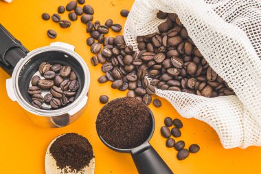 Kahvehanenin arka planında mesaj için yer var. Kahve çekirdekleri, bardaklar, boynuz ve değirmen turuncu arka planda.