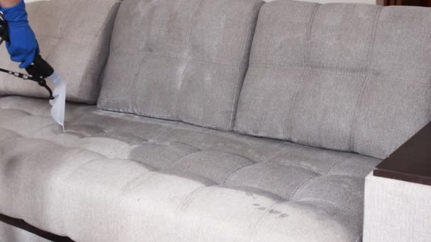 Servizio di pulizia. Uomo custode in guanti e uniforme aspirapolvere divano con attrezzature professionali — Video Stock