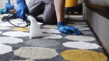 Temizlik servisi. Eldivenli hademe ve elektrikli süpürgeyle profesyonel ekipmanla temiz halı.