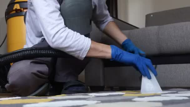 Schoonmaakdienst. Man conciërge in handschoenen en uniform vacuüm schoon tapijt met professionele apparatuur — Stockvideo