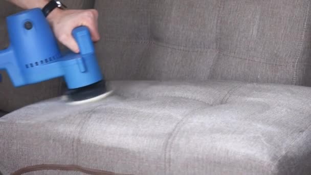 Reinigungsservice. Mann Hausmeister in Handschuhen und Uniform staubsaugen Sofa mit professioneller Ausrüstung — Stockvideo