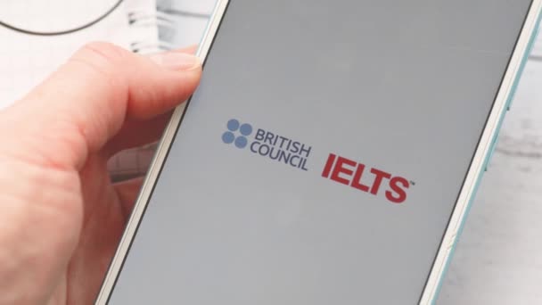 Ufa, Ryssland - 4 mars 2020: kvinna håller en smartphone i sina händer och klarar ett engelskt kunskapsprov IELTS — Stockvideo