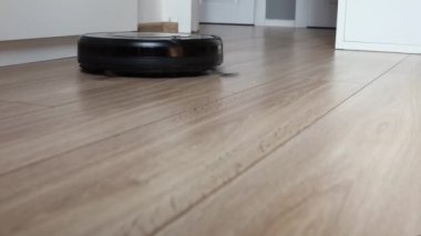 Yerdeki kendi kendine hareket eden robotik vakumun detaylı görüntüsü.