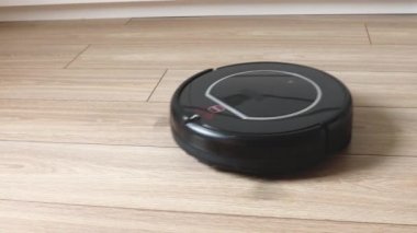 Yerdeki kendi kendine hareket eden bir robot süpürgeye yakın çekim görüntüsü.
