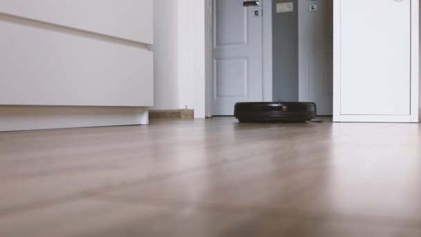 Close-up view on a self-moving robotic vacuum on the floor. — Stock Video